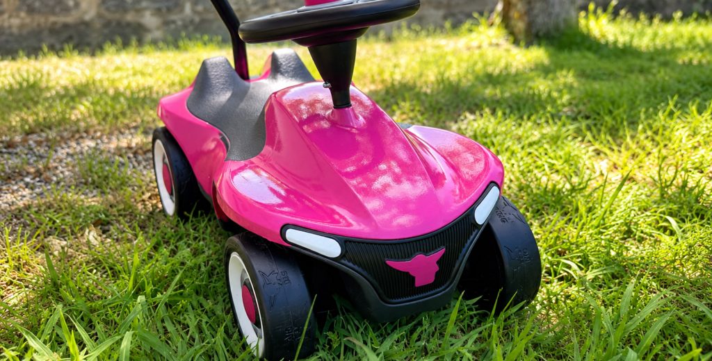 Magenta foliertes Bobbycar mit Blaulicht als Messeexponat auf einem Telekom Messestand