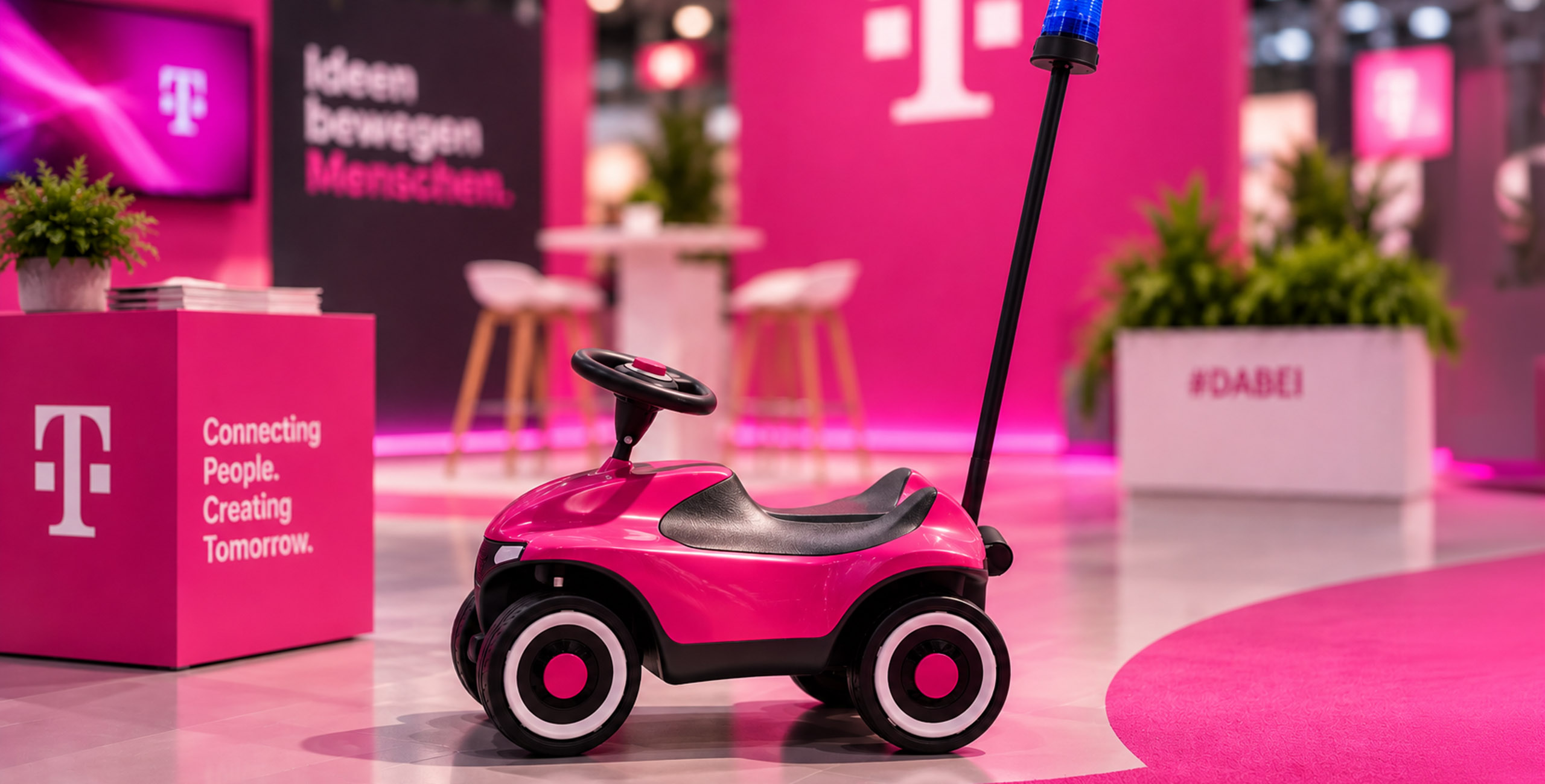 Magenta foliertes Bobbycar mit Blaulicht als Messeexponat auf einem Telekom Messestand